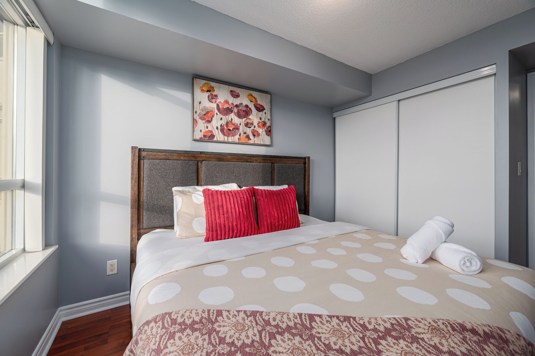 Quarto com cama, janela, quadro e guarda-roupa.