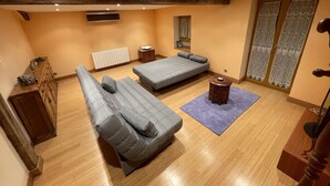 A compact room with two beds, a small table, a radiator, and a window with curtains. - 10 minutes from the Urkiola Natural Park (Izurtza)