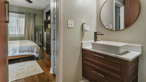 Un dormitorio con cama, mesita de noche y velador.