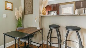 Una cocina con armarios de madera, una encimera y dos taburetes de bar.