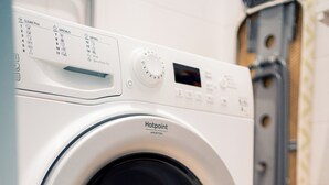 Vista frontal de uma máquina de lavar Hotpoint, com painel de controle, visor digital e porta frontal.