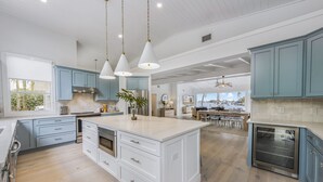 A spacious kitchen with light blue cabinets, a large island with drawers, and a built-in oven. - 4 Bed / 4 Bath with Stunning Views of Bimini Bay ! (Anna Maria)