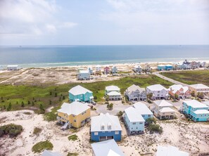 A coastal residential area with houses, a beach, and the ocean.