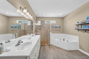 Un baño moderno con dos lavamanos, ducha y bañera.
