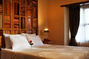 Relax in a serene space with a comfortable bed, a bedside table, and a window with dark curtains.
