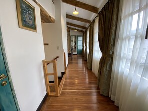 Stylish hallway with a wooden floor, chair, and framed artwork.