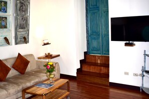 Relax in this stylish living room with a comfortable sofa, wooden coffee table, and wall-mounted TV.