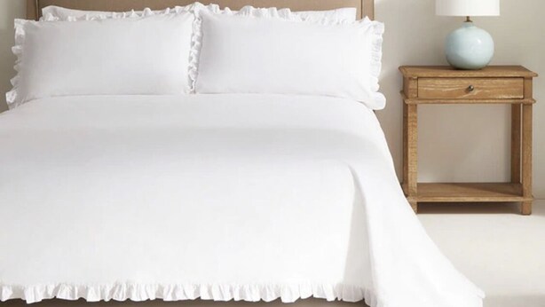 A bed with a headboard, two pillows, and a bedside table with a lamp. - Townhouse 300 meters from the sea (València)