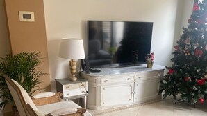A living room with a sofa set, a television, a Christmas tree, and a lamp. - Townhouse 300 meters from the sea (València)