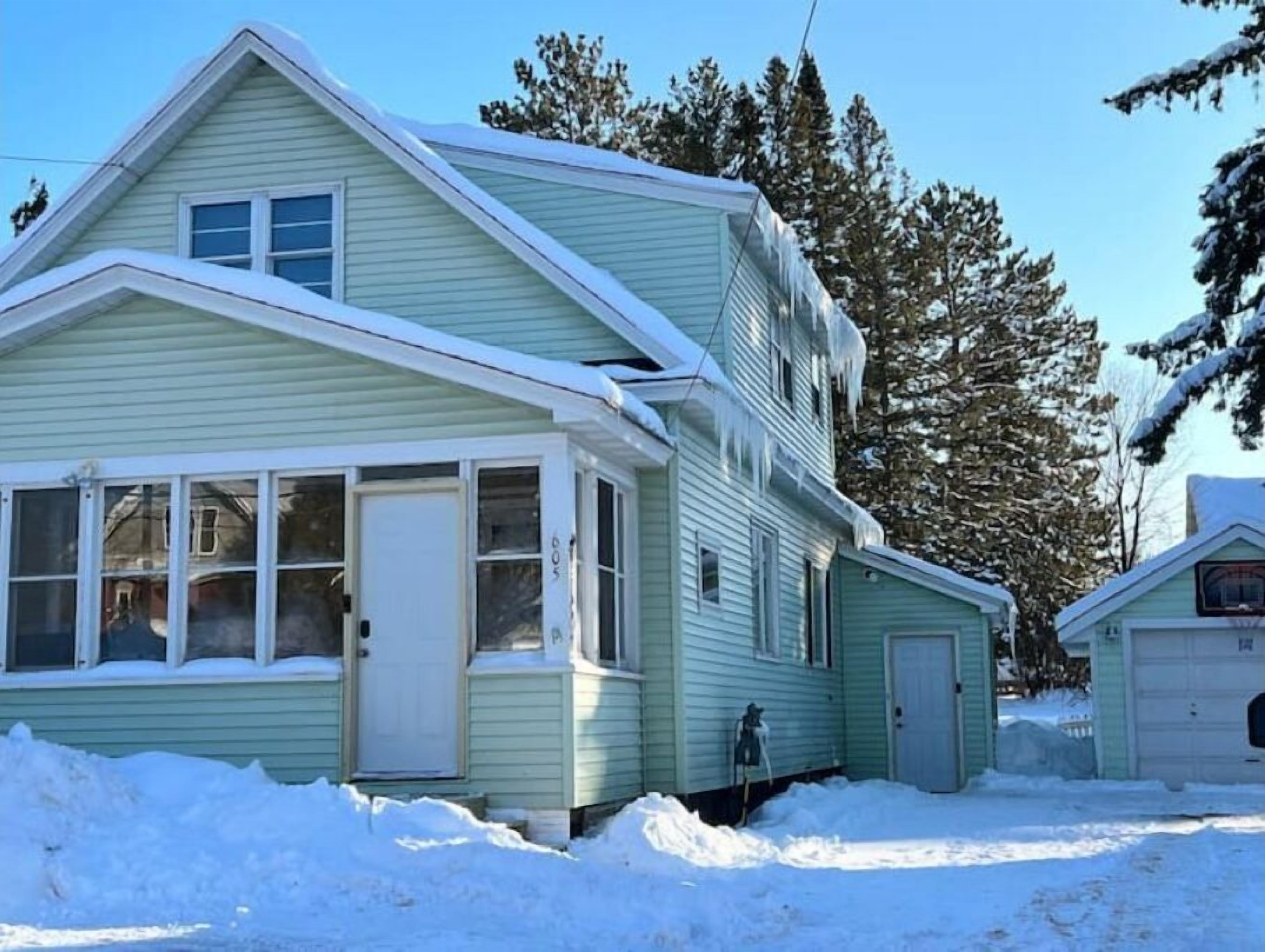 A two-story house with a gabled roof and a garage.