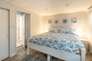 Une chambre à coucher comprenant un lit, une table de chevet et un mur orné de quatre assiettes décoratives.