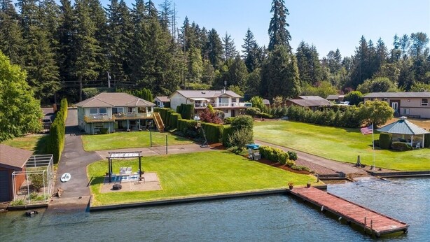 A residential area with houses, a dock, and a body of water. - Sunset Lake Retreat@ Lake Tapps-Lakefront, Spacious, Sports court, Kayaks (Lake Tapps)