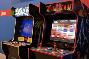 Twee speelautomaten, één voor Street Fighter II en de andere voor Mortal Kombat, met joystickbediening en kleurrijke knoppen.