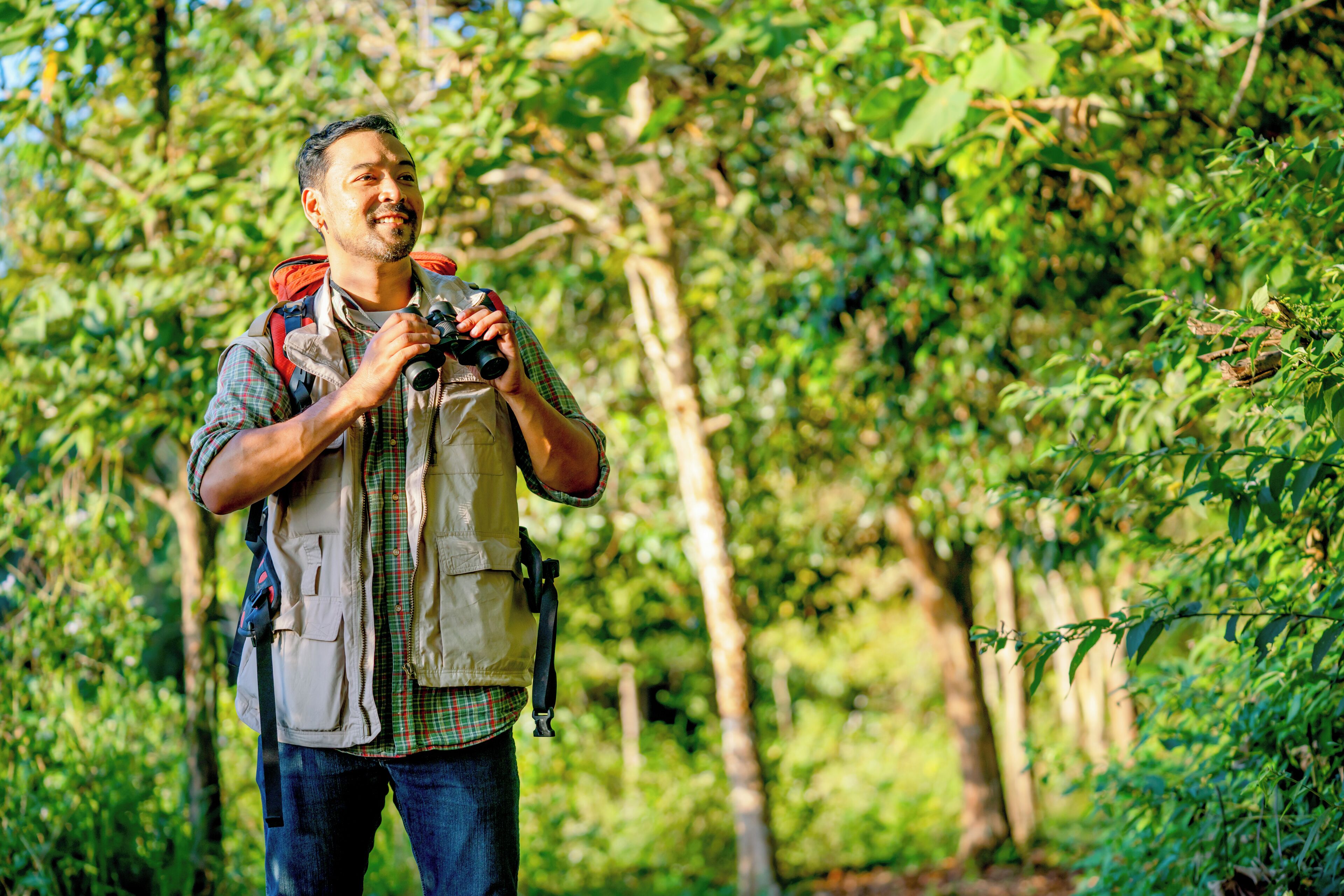 A person with a camera in a forested area.