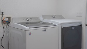 Une buanderie équipée de deux machines à laver à chargement frontal et d’un sèche-linge.