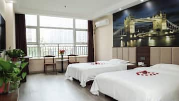 A hotel room with two beds, a dining table with chairs, a large window, and a painting of a bridge.