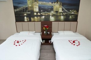 A hotel room with two beds, a night view of the Tower Bridge, and a small table with a vase of flowers. - Super 8 Hai'an North Yong'an Road Branch (Hai'an)