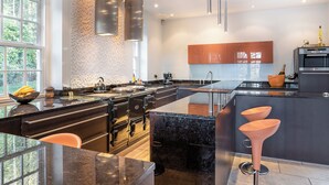 A modern kitchen with a large island, stainless steel appliances, and a view of the outdoors.