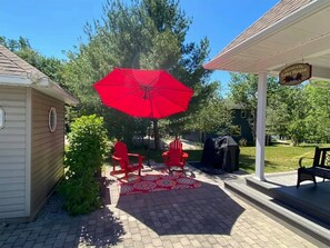 Enjoy dining and socializing in this outdoor space with a barbecue grill and comfortable seating.