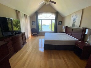 Enjoy a restful stay with a large bed, flat-screen TV, and a view of the outdoors through a large window.