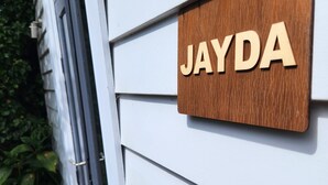 A wooden sign with the name "JAYDA" mounted on a white exterior wall. - Jayda- **A split level home with a magical ambience ** (Daylesford)