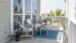En overdækket veranda med en træbænk, et bord og en potteplante.