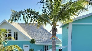 A house with a blue exterior, a white staircase, and a palm tree. - NEW POOL! Luxury waterfront! "Rainbow Charm" ***GAME ROOM!!*** (Rainbow bay)