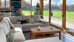 A modern living room with a sofa, a coffee table, and a Christmas tree. - 3 bedroom awesome home in Plélan-le-Petit (Plélan-le-Petit)