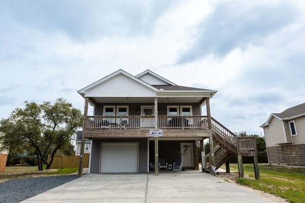 A two-story house with a balcony, a garage, and a staircase leading to the second floor.