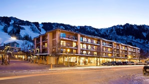 Un hôtel à plusieurs étages doté de balcons, d’un télésiège et offrant une vue sur les montagnes.