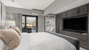 Une chambre moderne dotée d’un grand lit, d’un téléviseur à écran plat et d’un balcon avec vue.