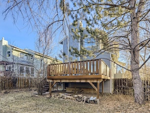 A wooden deck attached to a building with a staircase leading up to it.