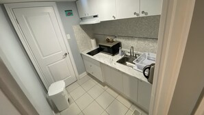A compact kitchen with white cabinets, a microwave, a sink, and a trash bin. - 2 Bedroom with 2 Ensuite Unit in the heart of Richmond HIll. (Richmond Hill)