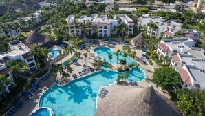 A resort with multiple swimming pools, palm trees, and resort buildings. - Playa Resort hamaca  (Boca Chica)
