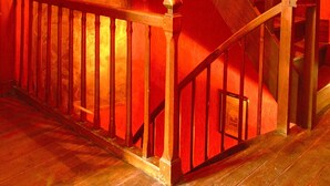 Un escalier en bois avec une rampe, un tableau encadré au mur et un plancher en bois.