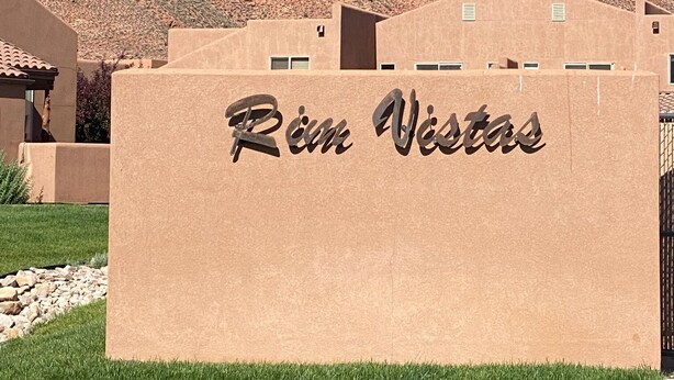 Un edificio con el letrero 'Rin Vistas' frente a un paisaje montañoso.