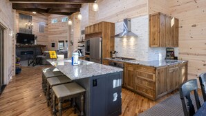 A modern kitchen with wooden cabinets, a granite countertop, and a built-in dishwasher. - EV Charger, Peloton Bike, Swing Set, Games, Pets (Broken Bow)