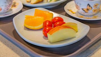Ein Teller mit Orangenscheiben und Tomaten auf einer Serviertablett.