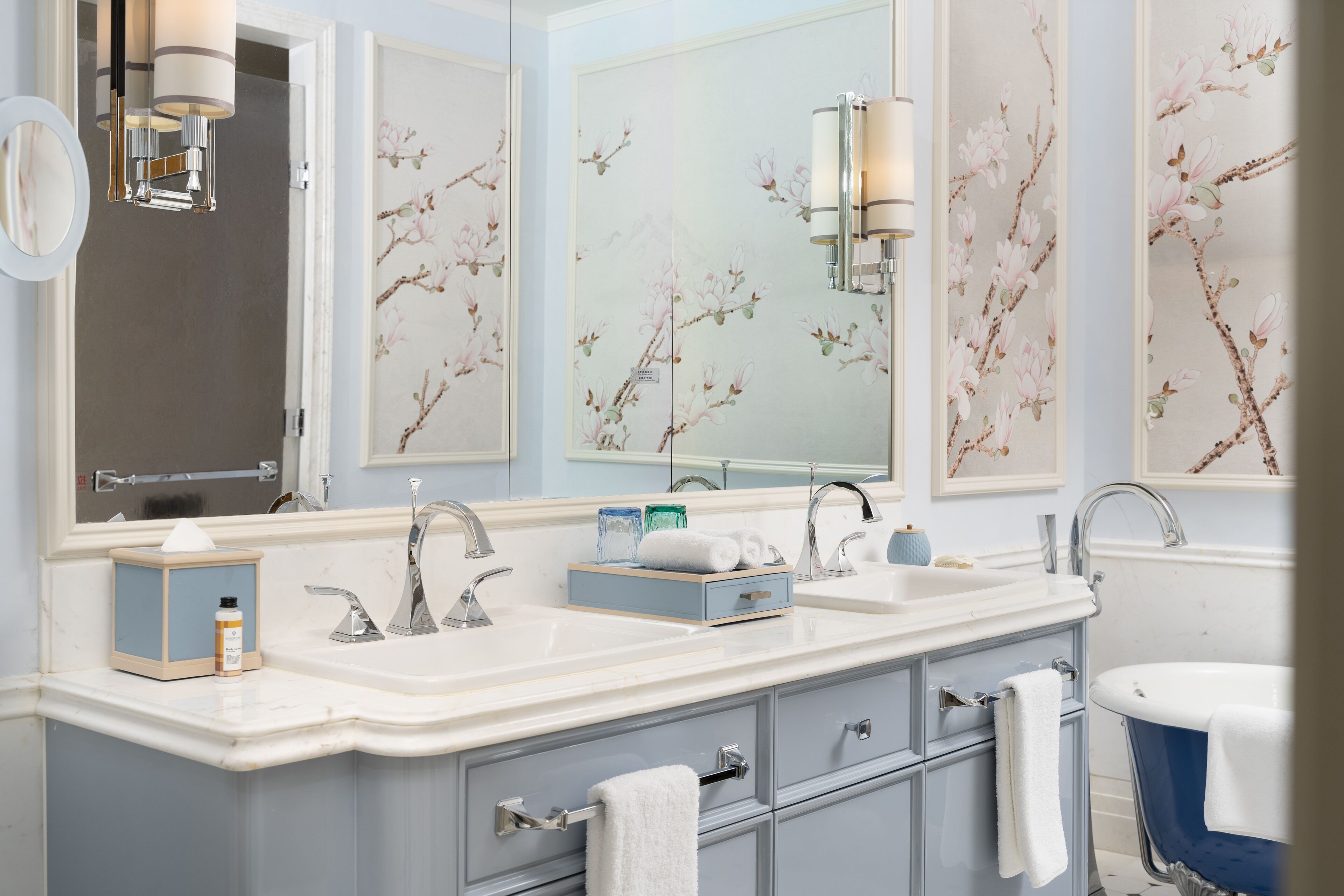 A bathroom with a double sink vanity, a mirror, and a bathtub.