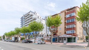 Un immeuble à plusieurs étages doté de balcons, d’un restaurant et d’une enseigne indiquant « À VENDRE ».