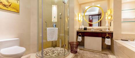 A modern bathroom with a glass-enclosed shower, a round mirror with a gold frame, and a marble floor.