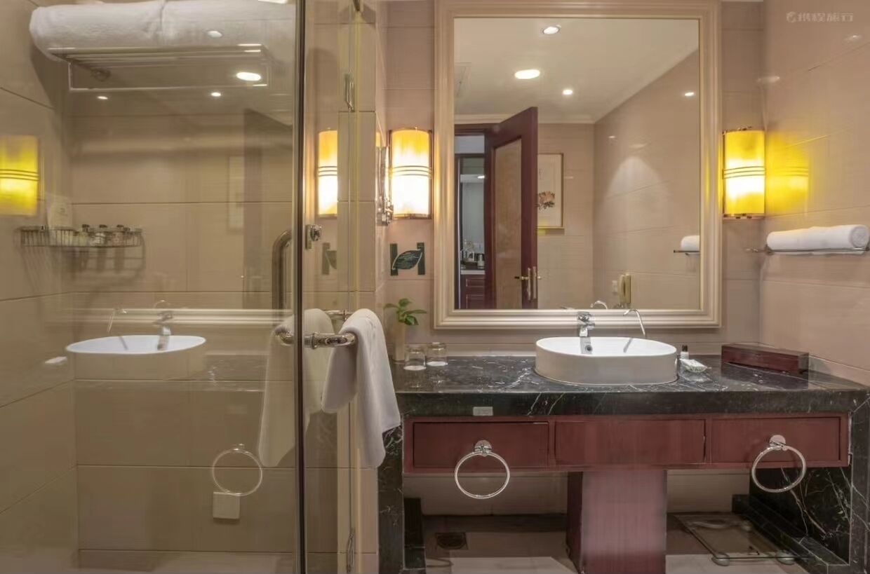 Une salle de bain moderne avec deux lavabos, un grand miroir et une douche à l’italienne.