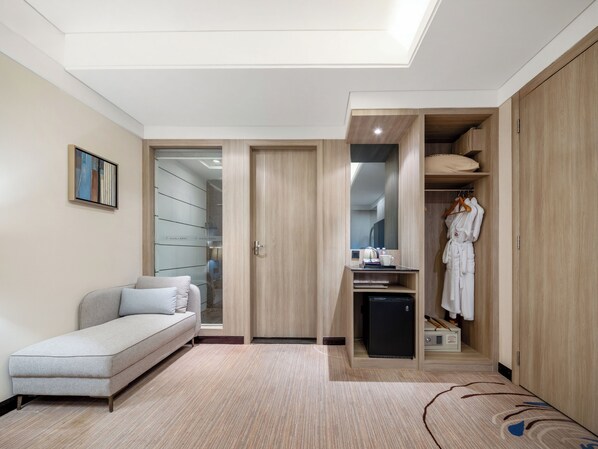 A modern hotel room with a sofa, a compact kitchenette, a walk-in closet, and a skylight. - Manli Hotel (Shenzhen)