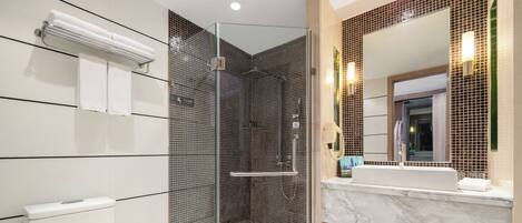 A modern bathroom with a glass-enclosed shower, a white toilet, and a marble sink.