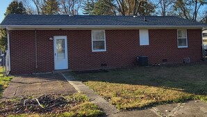 A single-story brick house with a front door, two windows, and a chimney. - Park Place-Quaint home nestled between parks and lakes (Olney)