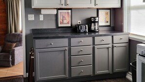 A kitchen with grey cabinets, a coffee maker, and a toaster on the counter. - Park Place-Quaint home nestled between parks and lakes (Olney)