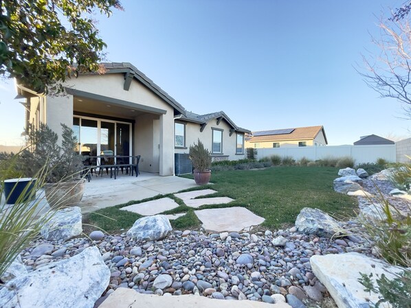 A residential house with a patio, a lawn, and a rock garden. - Former Model Home, 3 Car Garage, Gym, Sleep 14 (Lancaster)