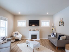 Smart TV, chimenea, libros y monitor de computadora 