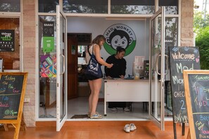 Una fachada con un cartel de tiza que dice “Welcome Mad Monkey” y un menú de tiza.