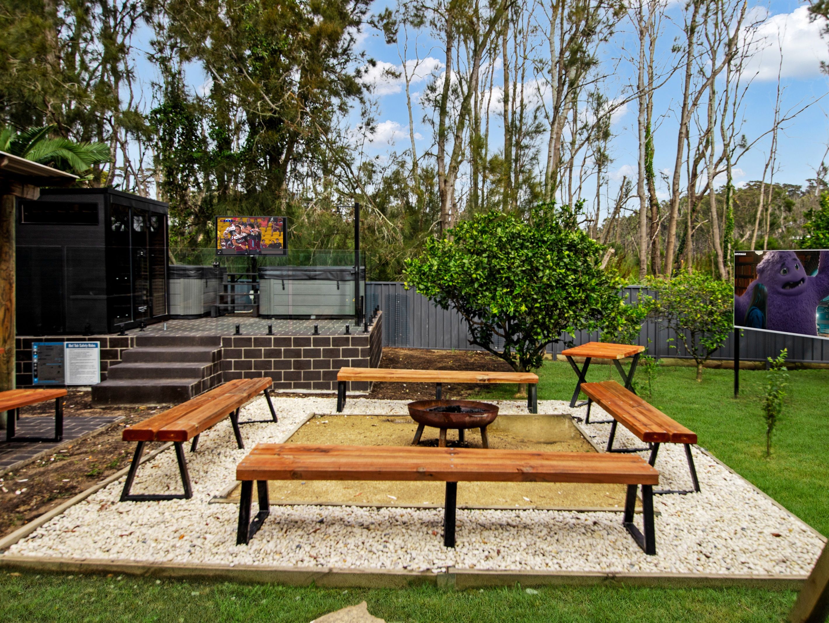 An outdoor patio area with wooden benches and a barbecue grill.